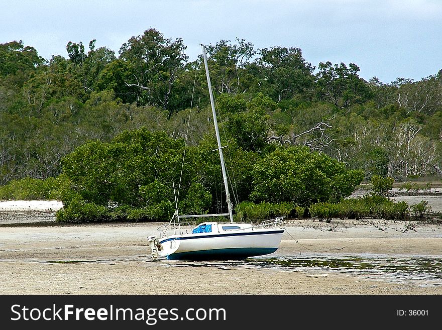 A sailing boat left high and dry waiting for the tide to come back in. Queensland, Australia. A sailing boat left high and dry waiting for the tide to come back in. Queensland, Australia.