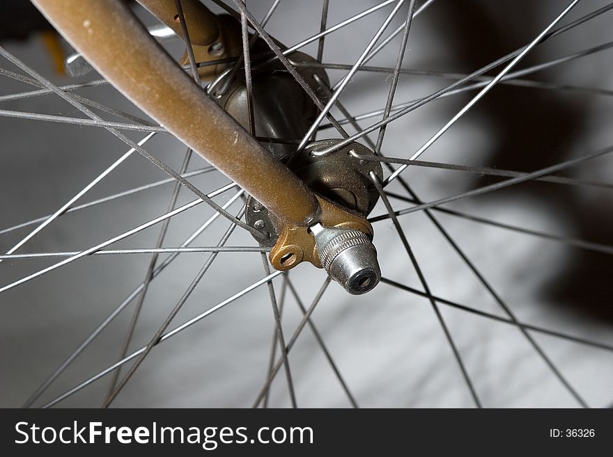 Front forks of a bicycle showing the connection of the front wheel and axle with spokes.