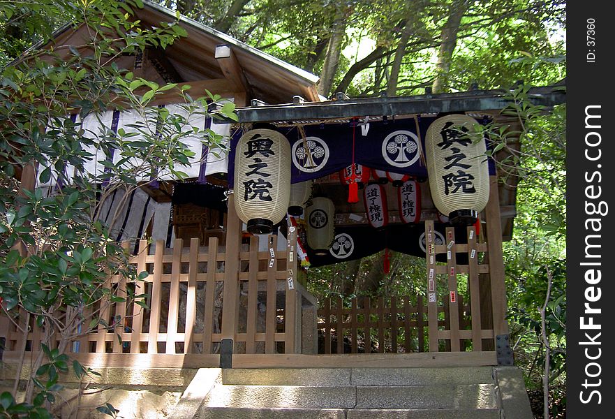 A wooden Japanese temple in the forest.