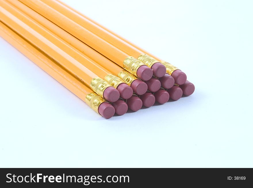 Several pencils stacked, eraser end yoward the camera, photographed on a white background. Several pencils stacked, eraser end yoward the camera, photographed on a white background