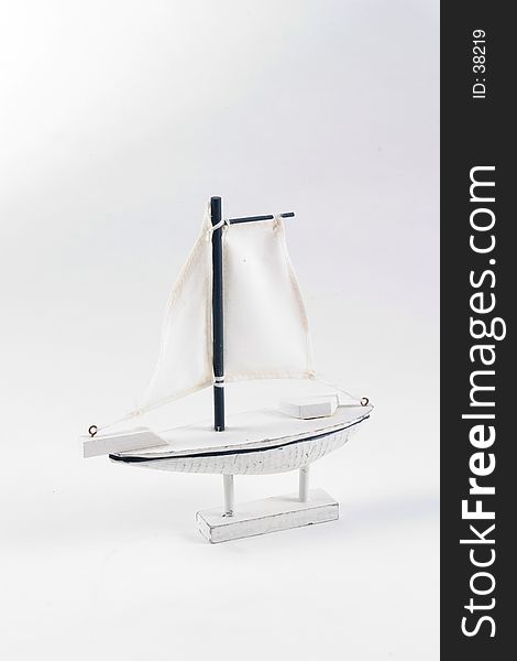Model of a sailboat made of wood. Boat is white photographed on a white background. Model of a sailboat made of wood. Boat is white photographed on a white background