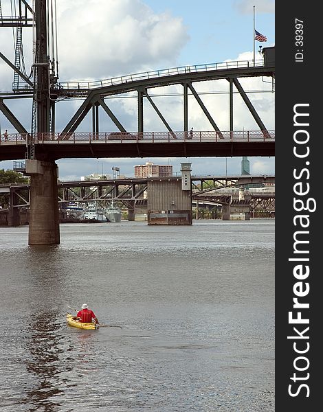 Man Kayaking under Bridges