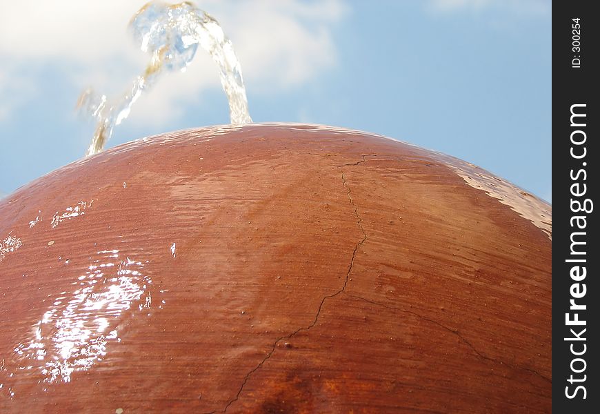 A Water fountain coming out of a concrete ball