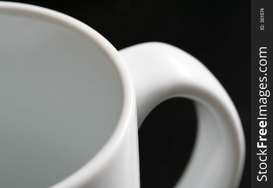 An empty white mug and its handle. An empty white mug and its handle