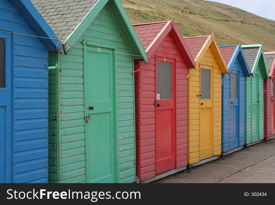 A line of colourful chalets by the sea