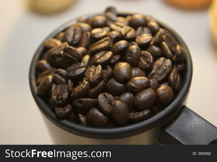 Coffee cup filled to the rim with beans. Coffee cup filled to the rim with beans