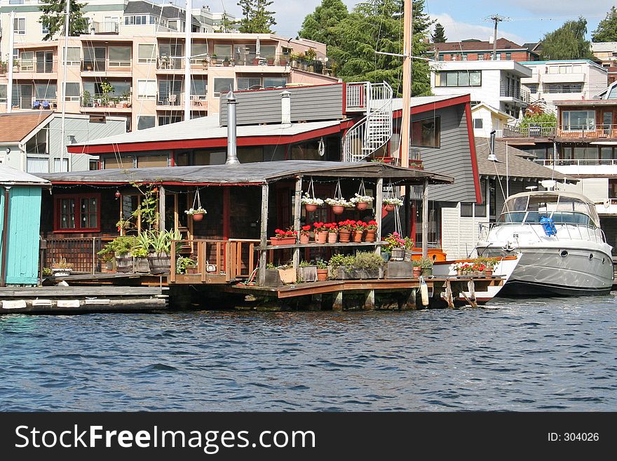 House suspended over the water with flowers on the porch. House suspended over the water with flowers on the porch