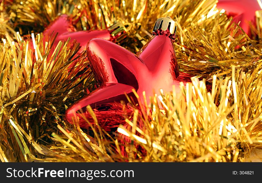 Red metallic Christmas stars and gold garland. Red metallic Christmas stars and gold garland