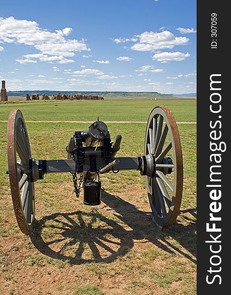 A Civil War-era cannon sits on the parade grounds of old Fort Untion National Monument, with the broken adobe walls of the post buildings in the background. A Civil War-era cannon sits on the parade grounds of old Fort Untion National Monument, with the broken adobe walls of the post buildings in the background.