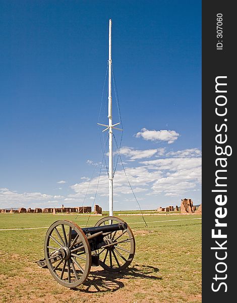A Civil War-era cannon sits in front of the flagpole on the parade grounds of old Fort Untion National Monument, with the adobe walls of the post buildings in the background. A Civil War-era cannon sits in front of the flagpole on the parade grounds of old Fort Untion National Monument, with the adobe walls of the post buildings in the background.