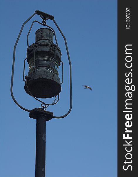 Old seashore lantern against a blue sky with seagull. Old seashore lantern against a blue sky with seagull