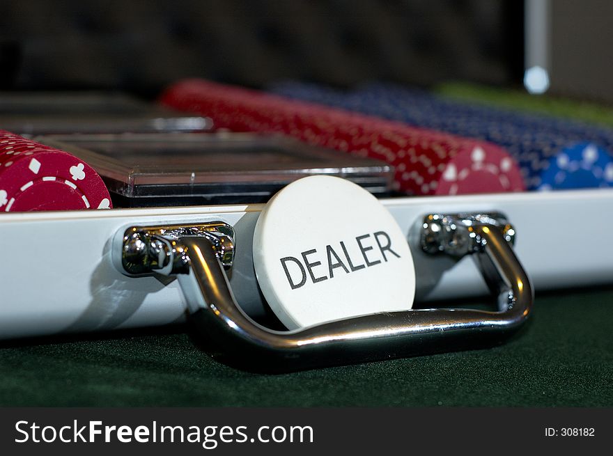 A case full of poker chips, with the dealer button in front. A case full of poker chips, with the dealer button in front