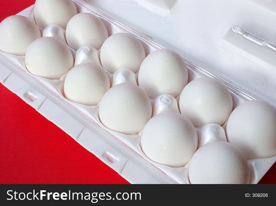 A dozen fresh eggs still in their carton. A dozen fresh eggs still in their carton