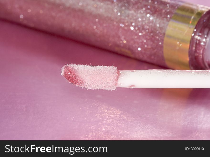 Brush with pink gloss for lips