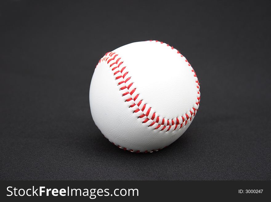 On a black background a baseball ball