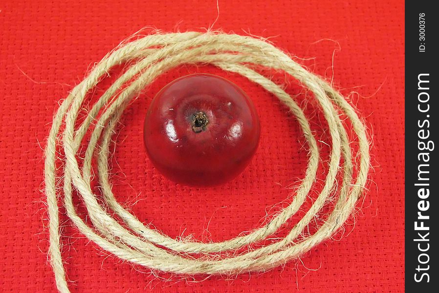 Nature, composition: red apple and string on red tissue