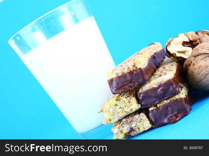 Pouring white milk against blue background and glass. Pouring white milk against blue background and glass