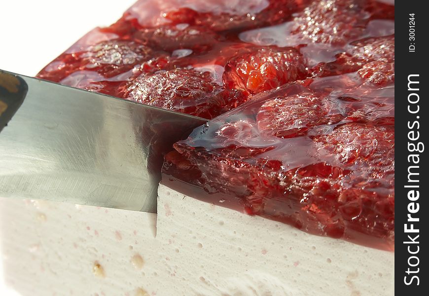 Raspberry cake cutting with a knife
