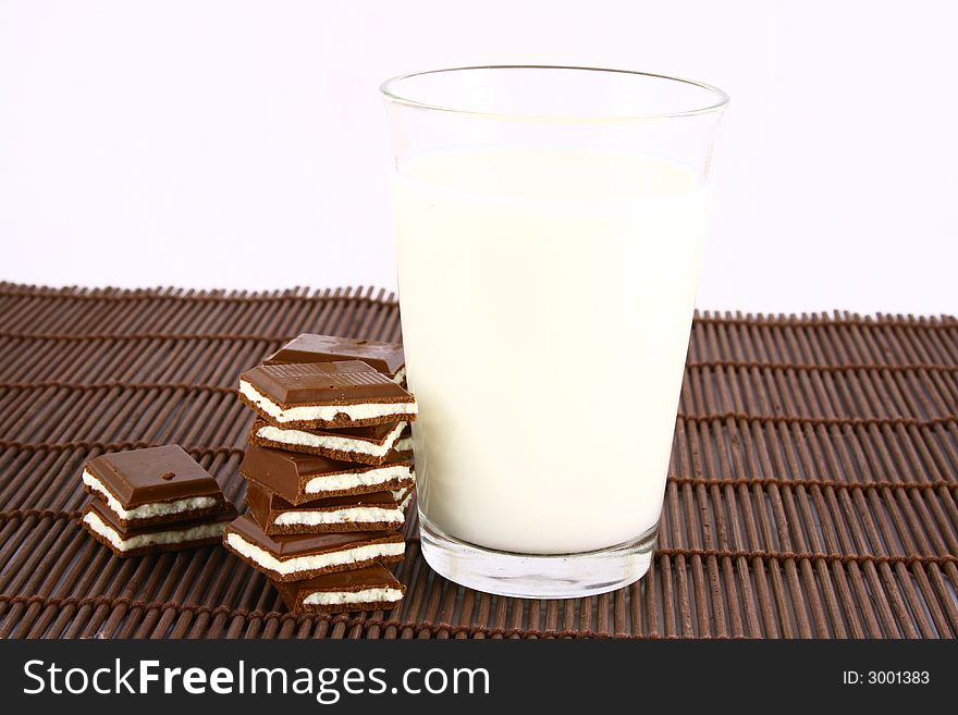 Pouring white milk against blue background and chocolate. Pouring white milk against blue background and chocolate