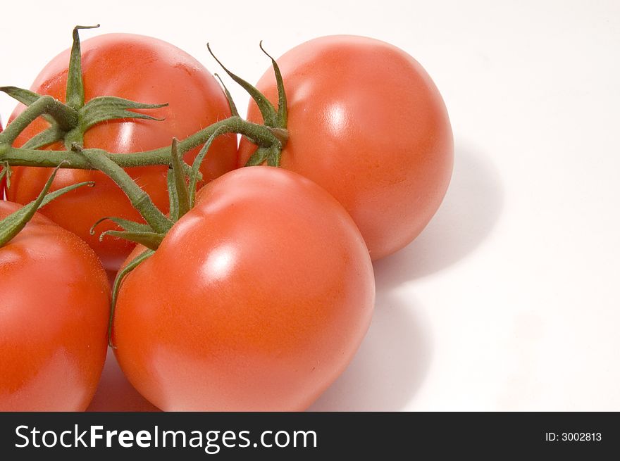 Four red juicy tomatoes on white background