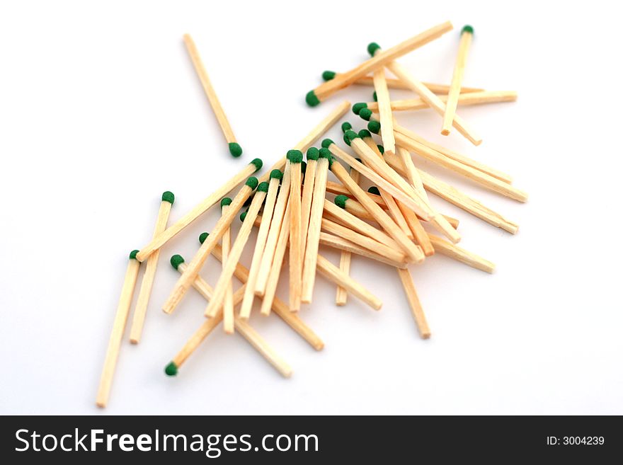 Some green matches laying on a white background