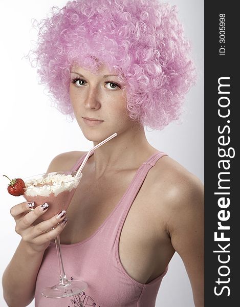 Pretty girl in pink dress and wig with strawberry cocktail