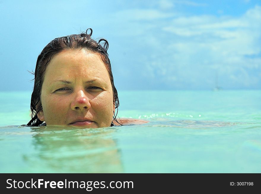 Mid age woman swimming in crystal clear turquoise ocean, Seychelles. Mid age woman swimming in crystal clear turquoise ocean, Seychelles