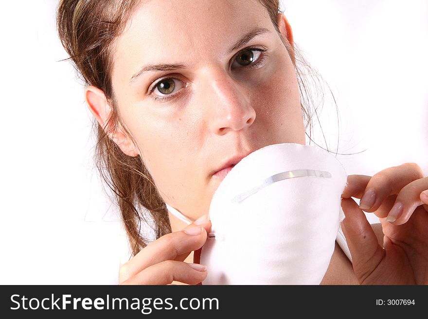 A young female doctor puts on her face mask. A young female doctor puts on her face mask.