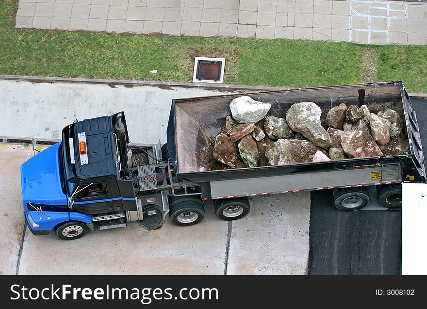 A large dump truck filled with massive boulders. A large dump truck filled with massive boulders