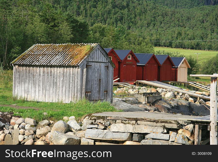 Old weathered and some new boathouses by a sea