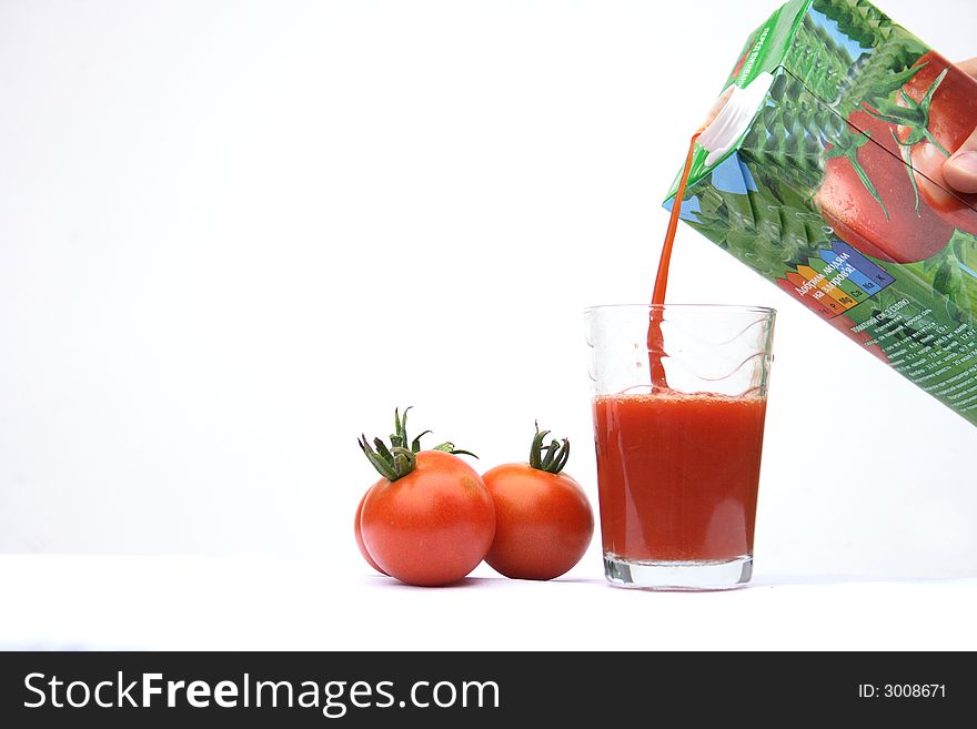 On a photo tomatoes and a glass of tomato juice.