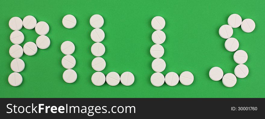 Word pills made of pills, on green background