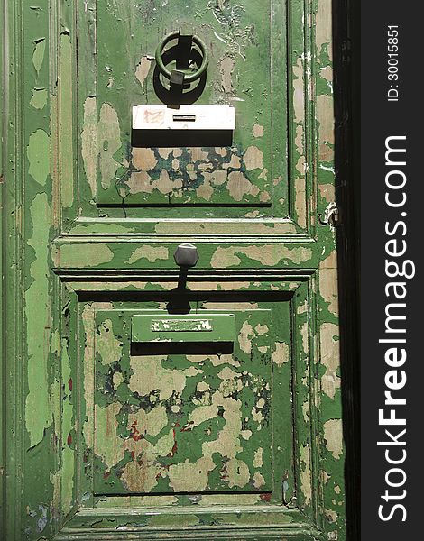 Heavily weathered green door with peeling paint. Heavily weathered green door with peeling paint