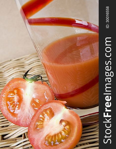 Two pieces of fresh tomato put beside tomato juice glass. Two pieces of fresh tomato put beside tomato juice glass
