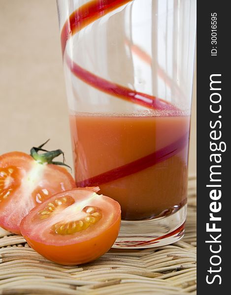 A glass of tomato juice with fresh tomato