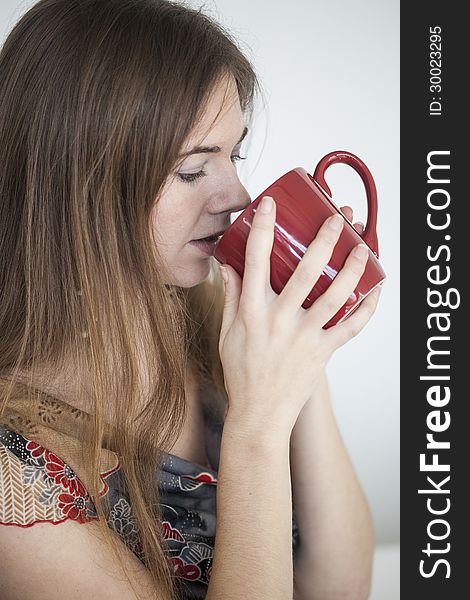 Young Woman with Beautiful Green Eyes with Red Coffee Cup