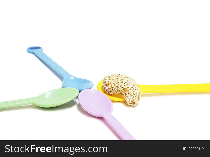 A sweet cashew nut with sesame on colorful spoon