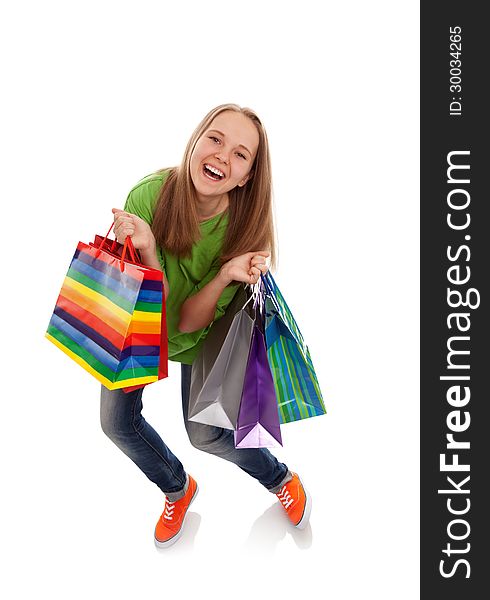 The happy attractive teenager girl standing with bags for purchases on a white background. The happy attractive teenager girl standing with bags for purchases on a white background