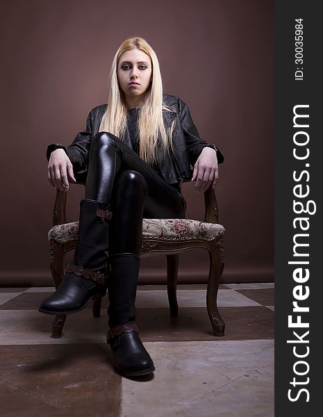 Sensual rock girl in a vintage chair studio shot