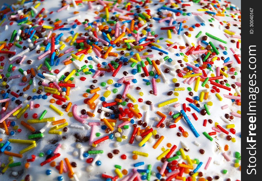 Close-up of an Easter cake with white sugar icing speckled with colored candy sprinkles. Close-up of an Easter cake with white sugar icing speckled with colored candy sprinkles
