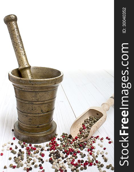 Antique mortar and pepper on white wooden background