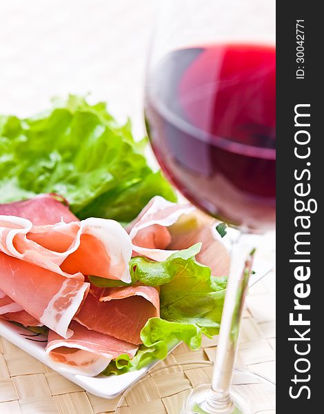 Glass with red wine and ham