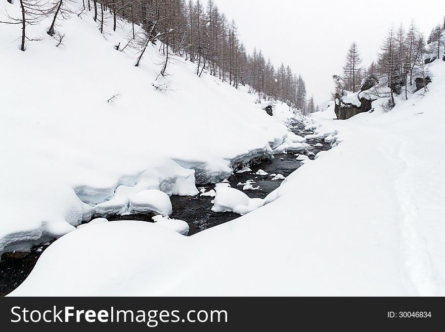 A winter landscape with river and mountain in the background. A winter landscape with river and mountain in the background