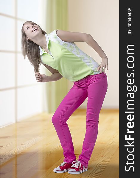 Fashionable teen girl full length standing in pose, looking up and laughing brightly. Indoor. Fashionable teen girl full length standing in pose, looking up and laughing brightly. Indoor