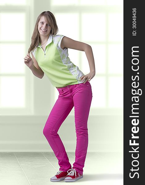 Fashionable blondy teenage girl full length standing in pose, smiling brightly. Indoor. Fashionable blondy teenage girl full length standing in pose, smiling brightly. Indoor