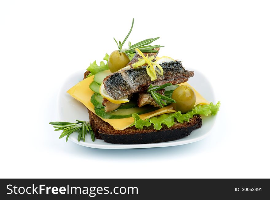 Delicious Snack of Smoked Sardines, Lettuce, Cucumber, Cheese, Olives with Lemon, Rosemary and Whole Wheat Bread on White Plate on white background. Delicious Snack of Smoked Sardines, Lettuce, Cucumber, Cheese, Olives with Lemon, Rosemary and Whole Wheat Bread on White Plate on white background