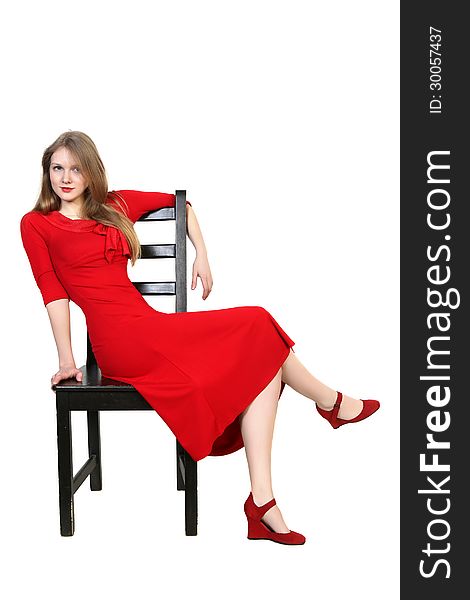 Portrait of beautiful blonde in red dress sitting on a chair. Isolated on white background. Portrait of beautiful blonde in red dress sitting on a chair. Isolated on white background