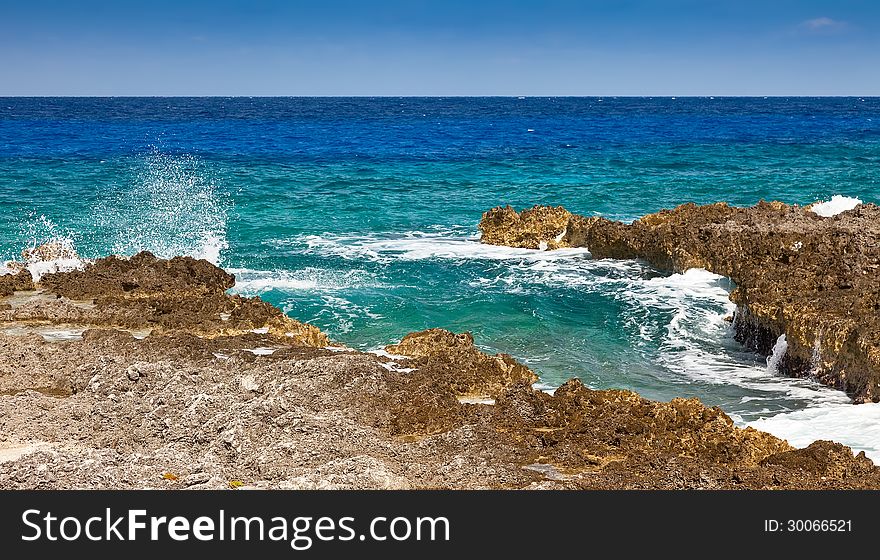 Caribbean Sea splashing against the shore in Grand Cayman, Cayman Islands