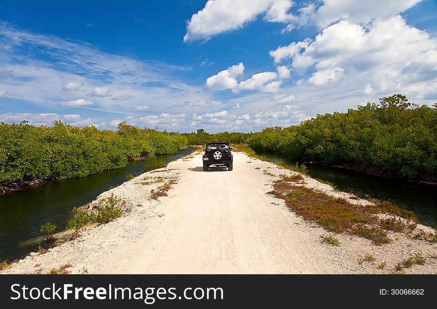 SUV driving on dirt road in Grand Cayman, Cayman Islands. SUV driving on dirt road in Grand Cayman, Cayman Islands