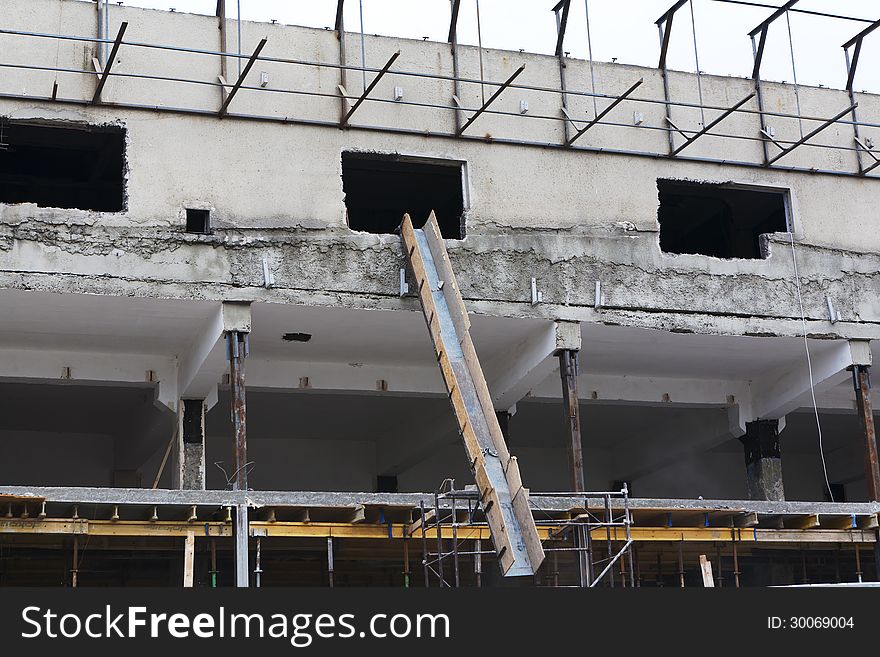 Concrete house under construction with chute and building woods